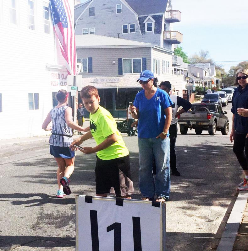 Domenic Fringuelli, 11, of Wareham passes out water to runners at the 1-mile mark. BY MATTHEW BERNAT